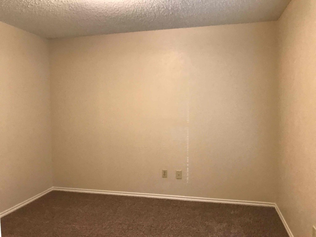 a empty room with white walls and a carpet