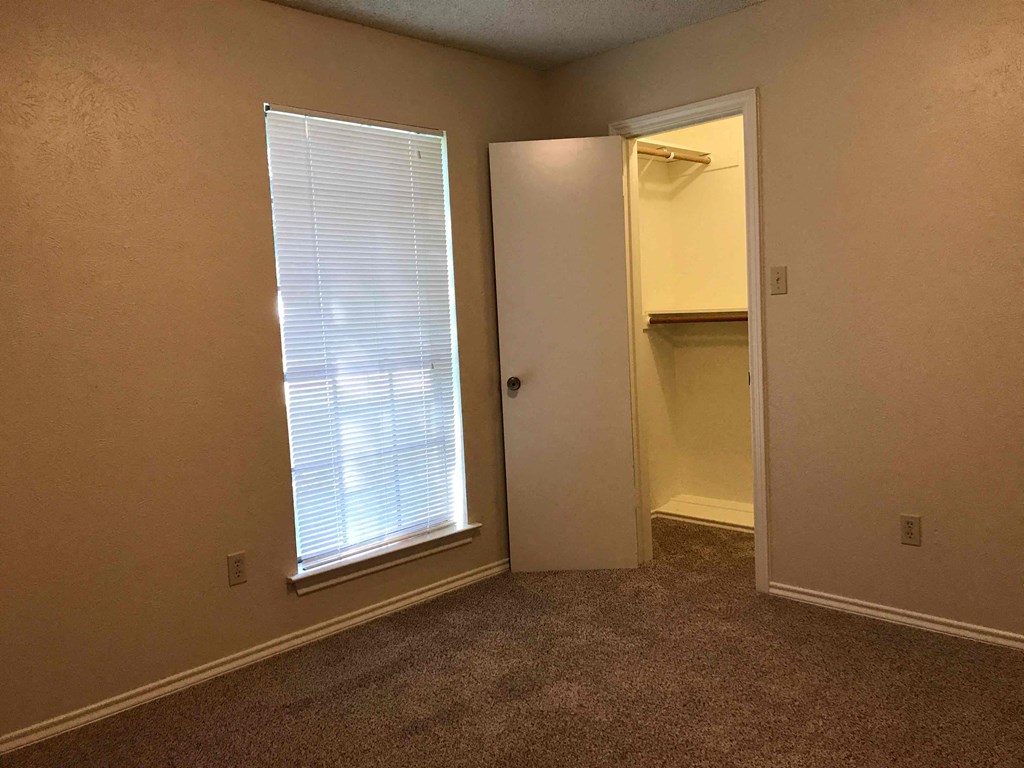 a room with a door to a closet and a window