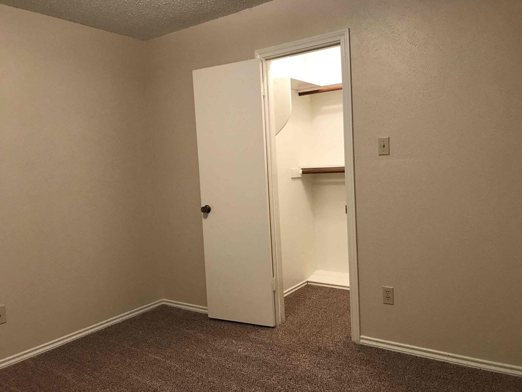 a small room with a closet and an open door