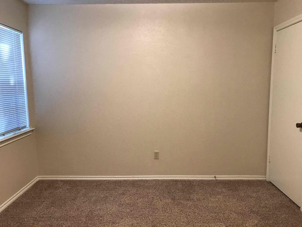 a empty room with a window and a carpet