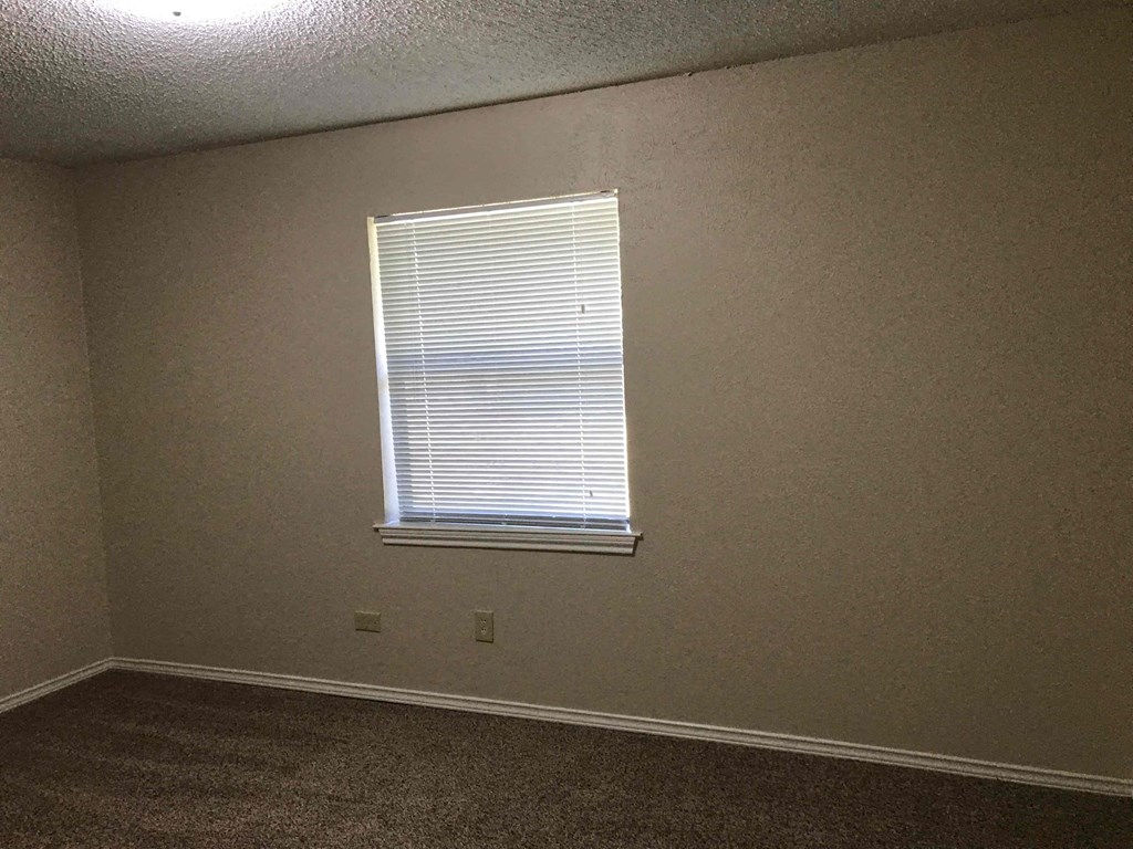 a room with a window and a carpeted floor