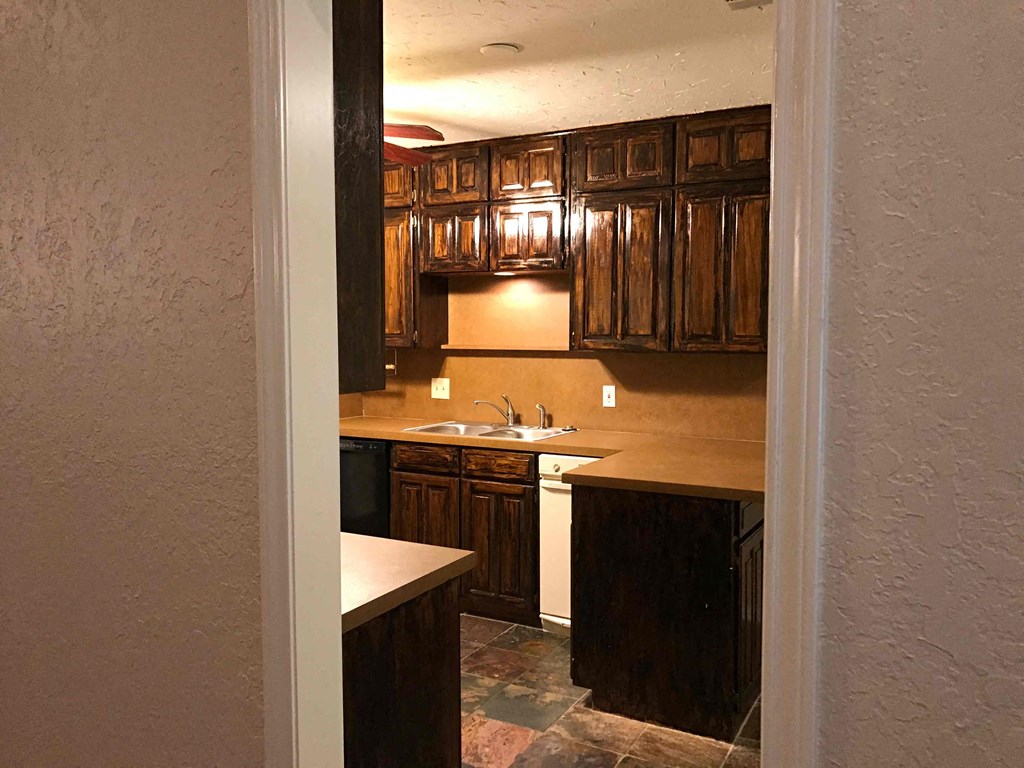 a view of a kitchen with wooden cabinets and a sink