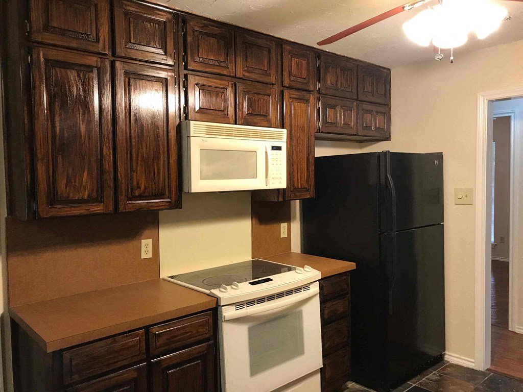 a kitchen with a stove and microwave and a refrigerator