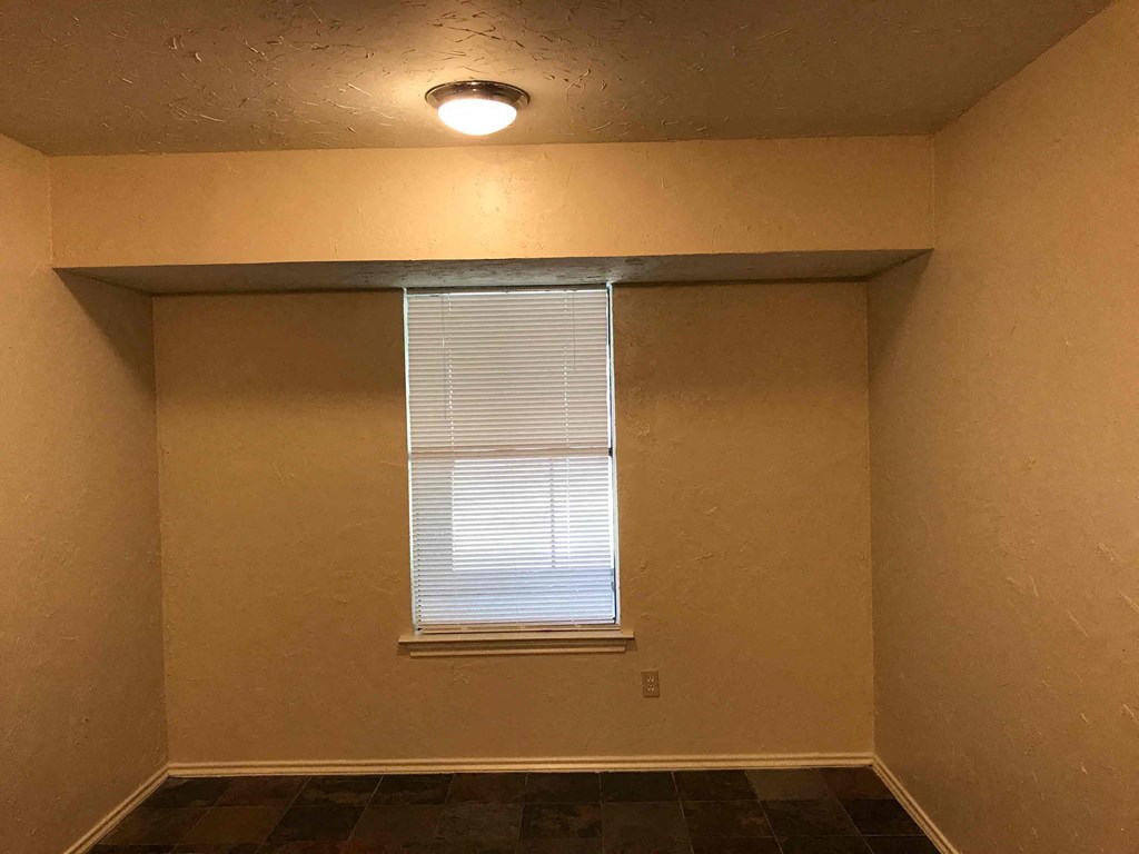 an empty room with a window and a light on the ceiling