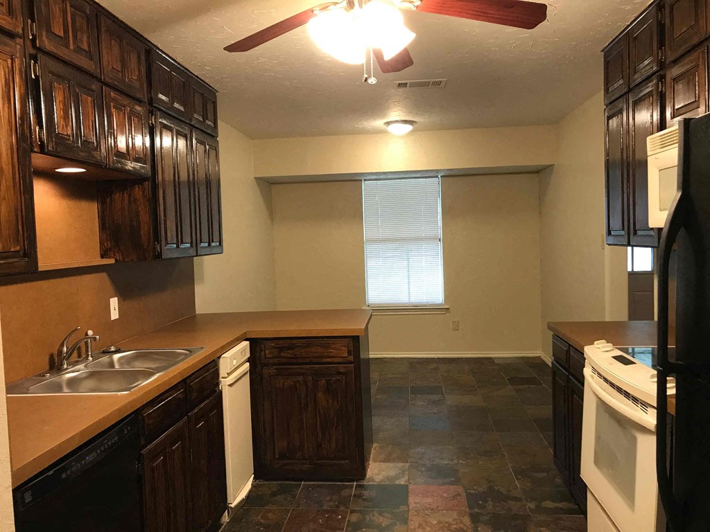 a kitchen with dark wood cabinets and a sink