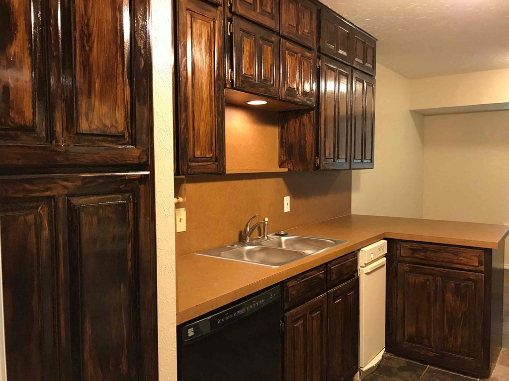 a kitchen with dark wood cabinets and a sink