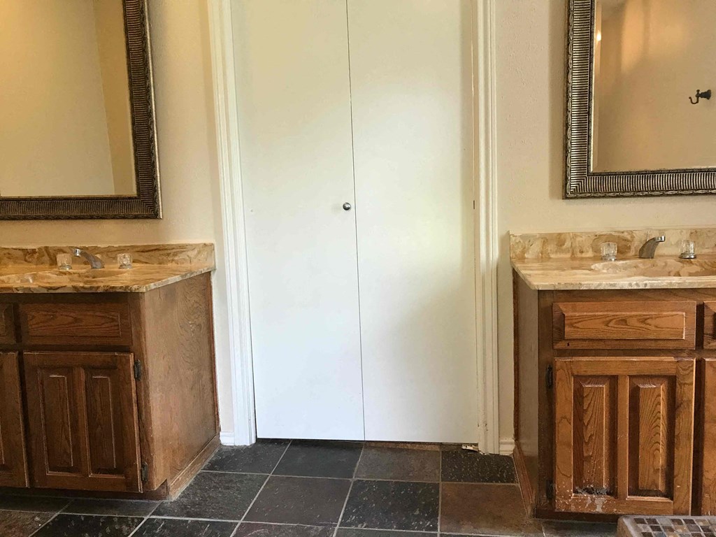 a bathroom with two sinks and a mirror and a closet