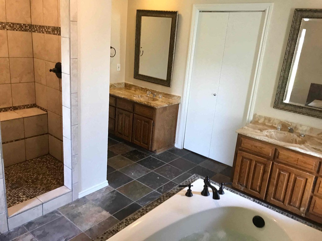 a bathroom with a tub and a shower and a sink