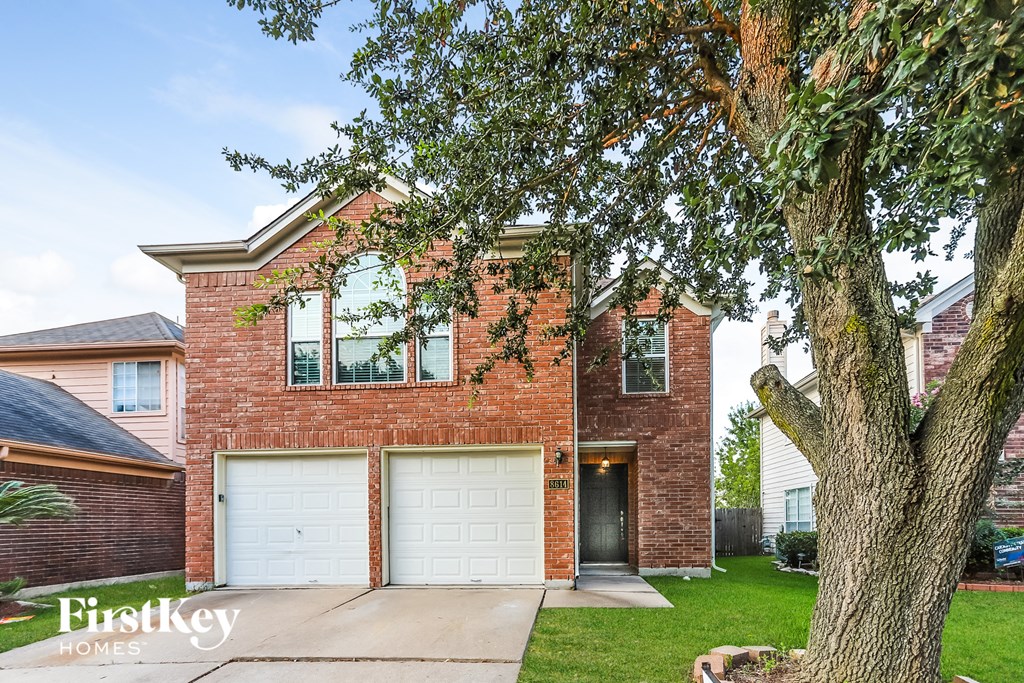 A brick house with a tree in front of it.