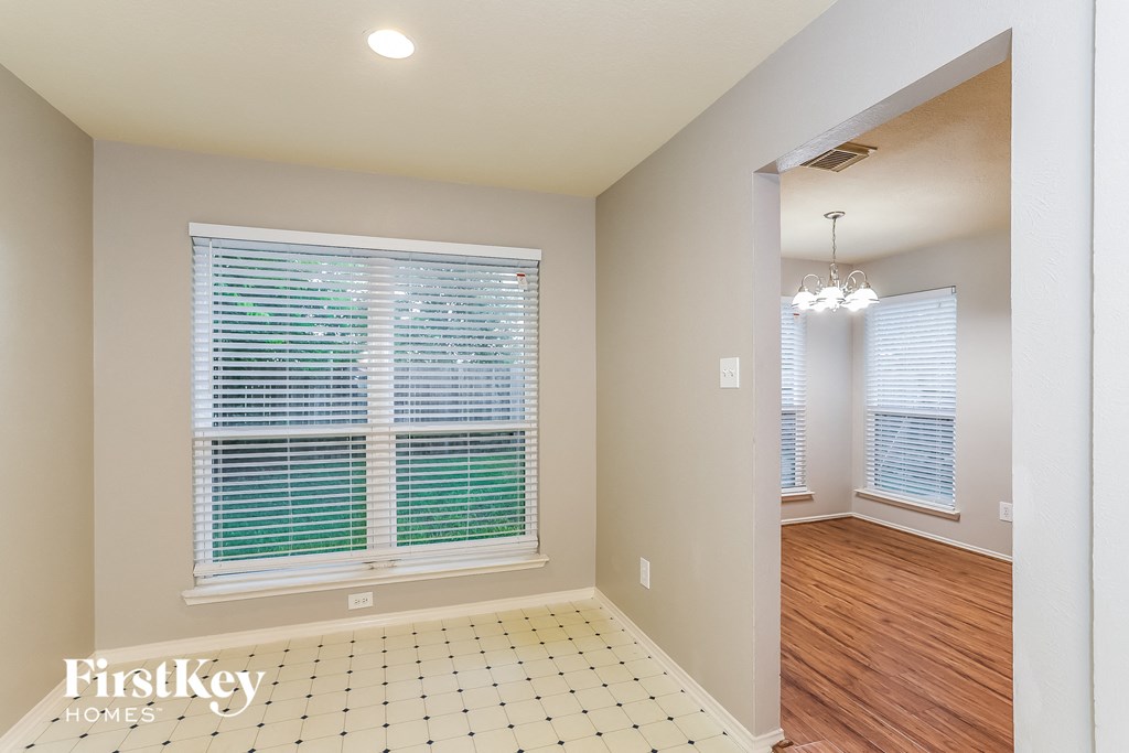 A room with a tiled floor and a window with blinds.