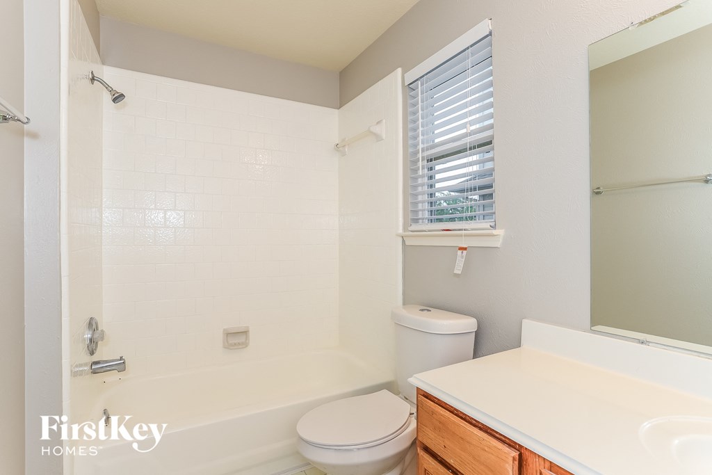 A white bathroom with a toilet, sink, and shower.