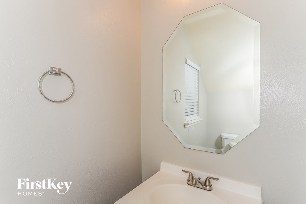 A white sink under a mirror in a bathroom.