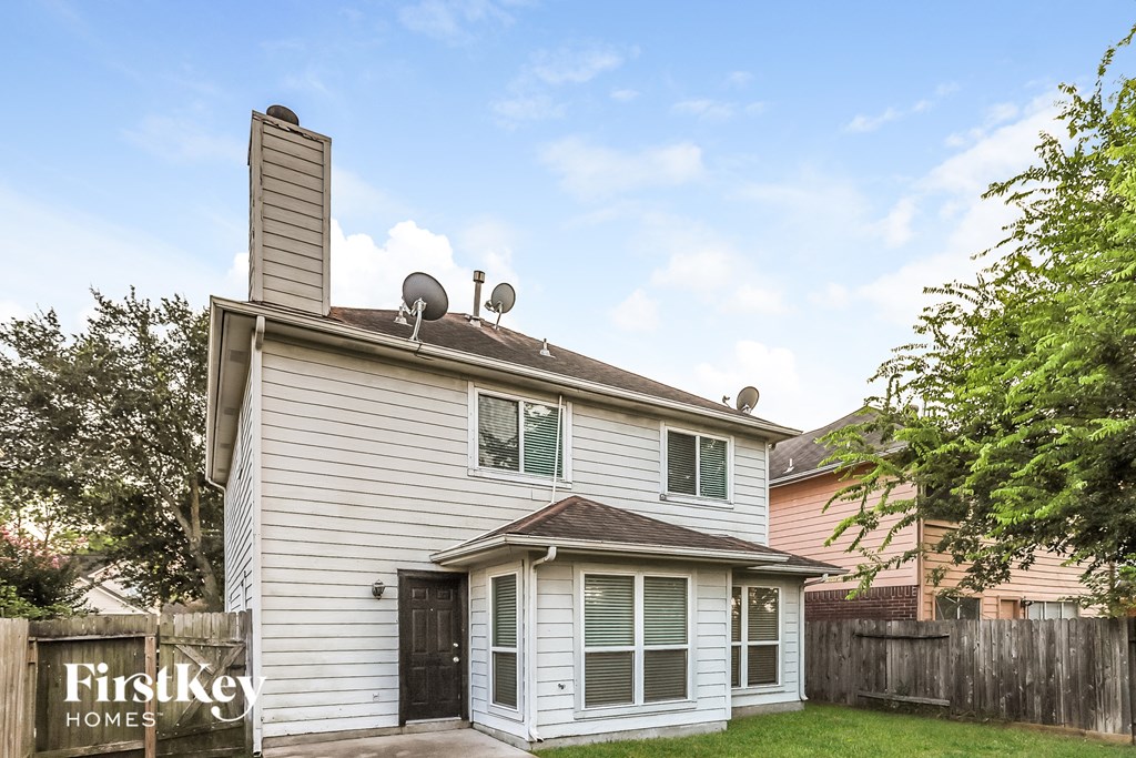 A house with a white siding and a brown roof is for sale.