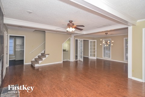 an empty living room with a ceiling fan