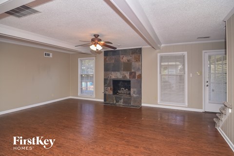 a living room with a fireplace and a ceiling fan