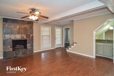 a living room with a fireplace and a ceiling fan