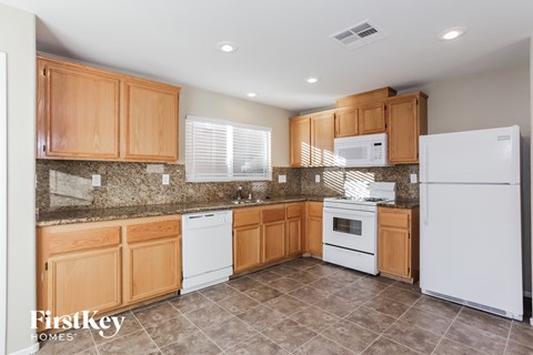 A kitchen with wooden cabinets and a white refrigerator.