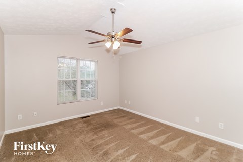 a bedroom with carpet and a ceiling fan