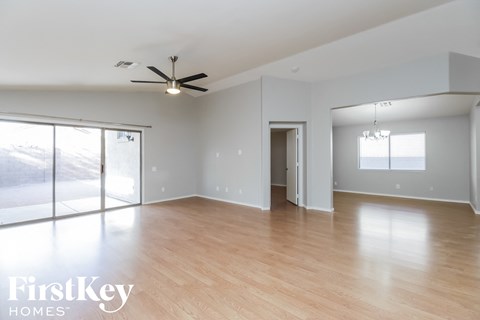 A spacious room with a ceiling fan and wooden flooring.