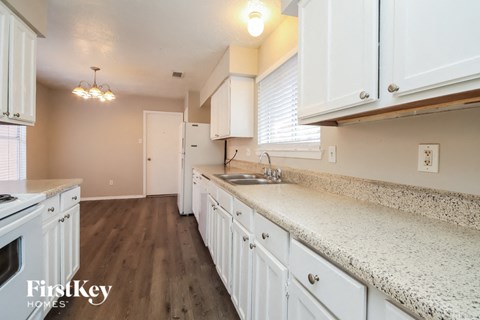 a kitchen with white cabinets and a counter top and a sink