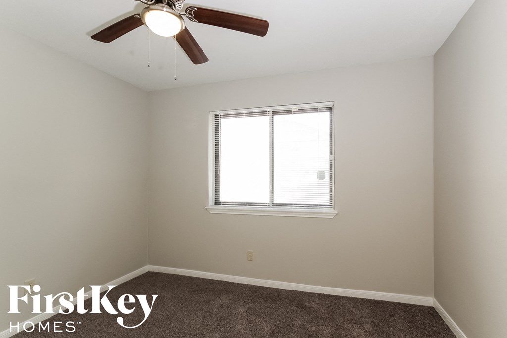 a bedroom with a ceiling fan and a window