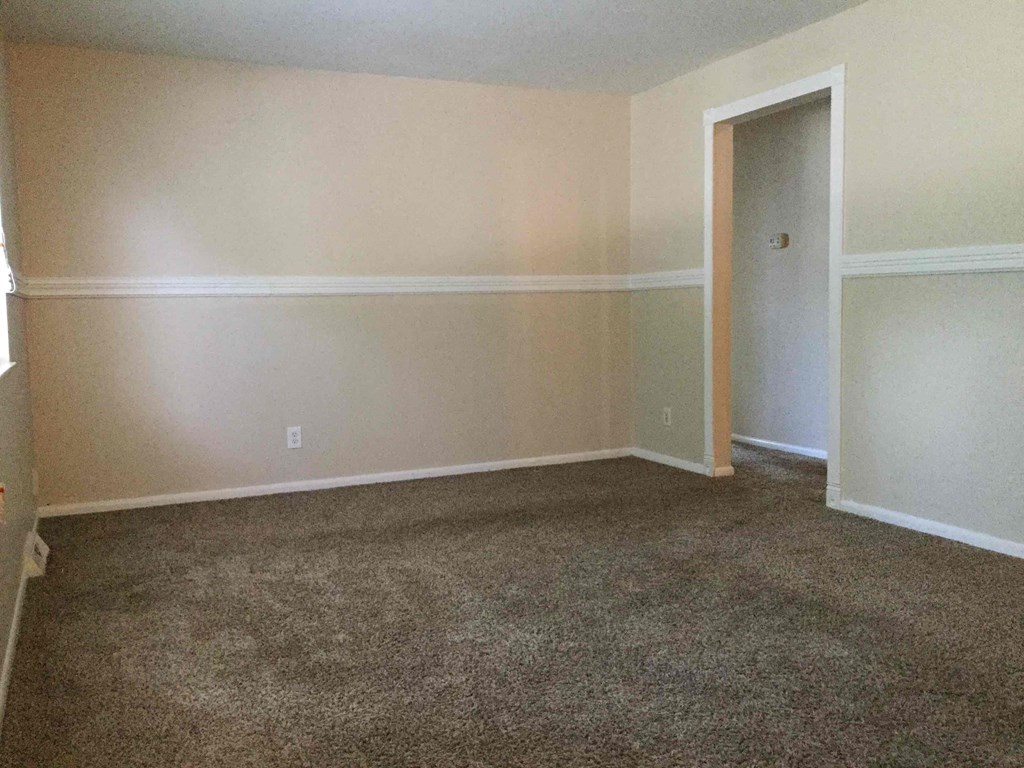 A room with a carpeted floor and a door.