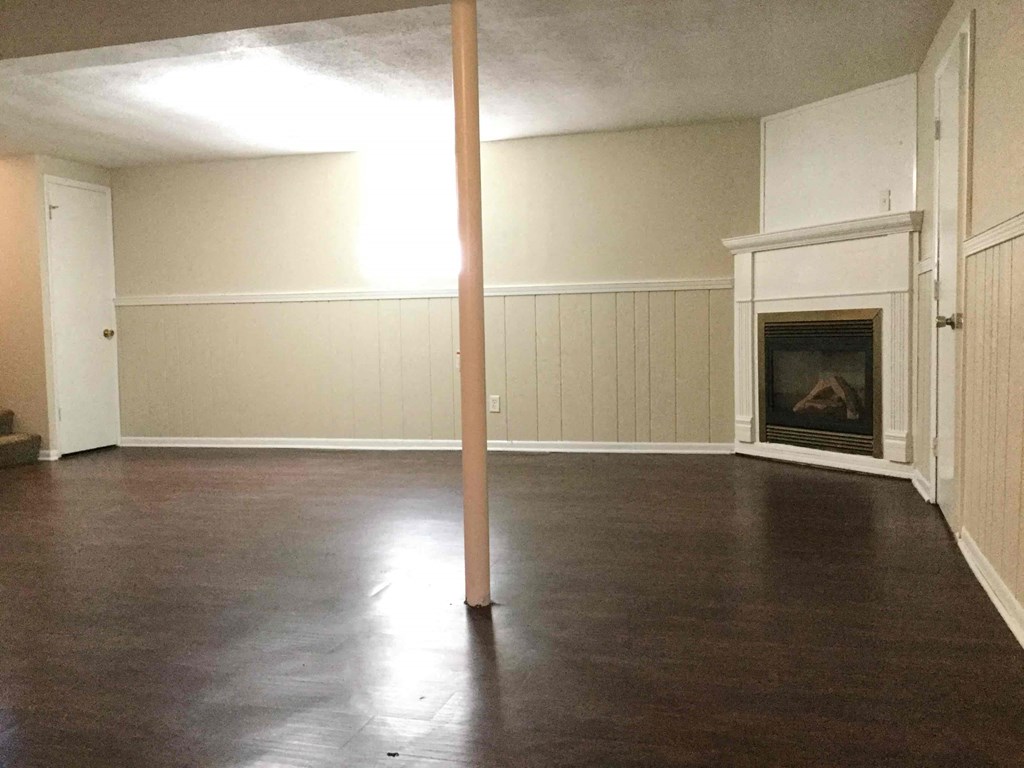 A room with a fireplace and a pole in the middle.