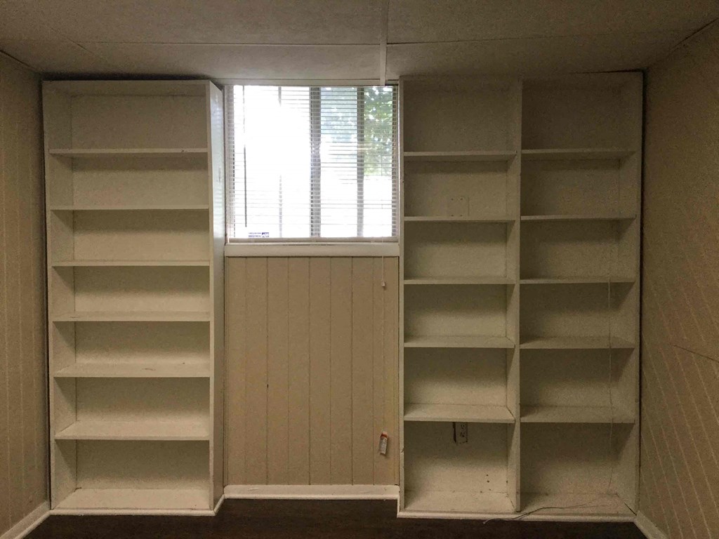 Empty shelves in a room with a window.
