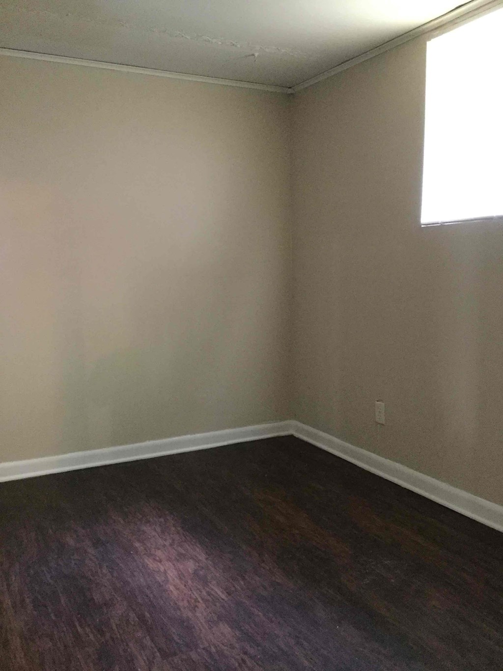 A room with a wooden floor and a window.