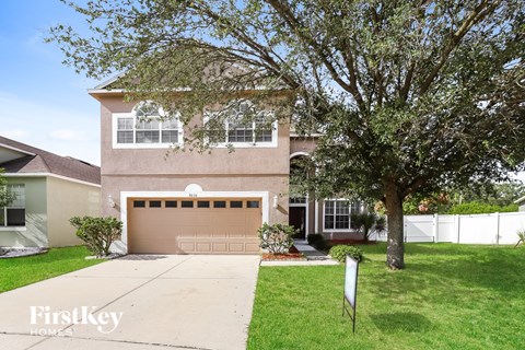 a house with a garage door and a tree