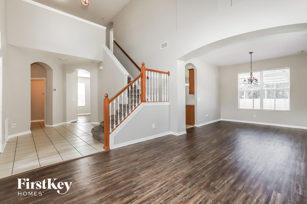 an empty living room with a staircase in the corner