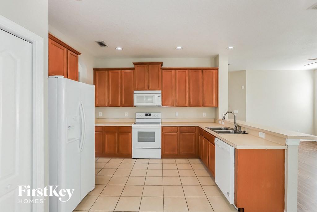 a kitchen with white appliances and wooden cabinets