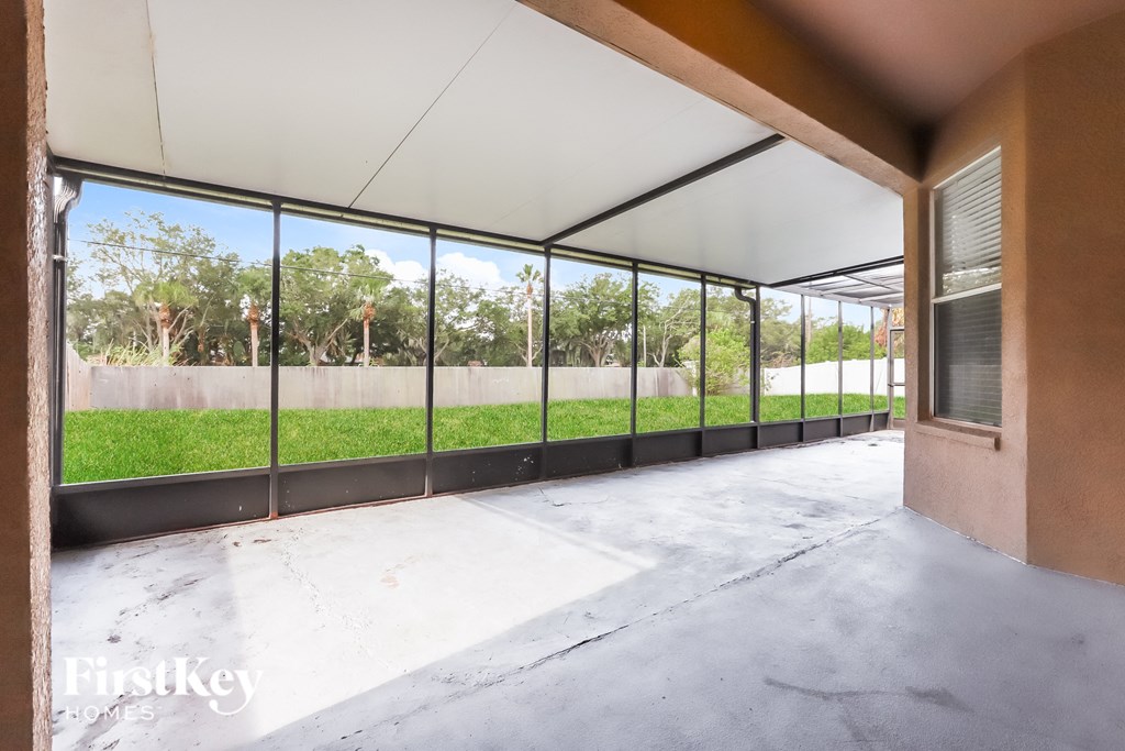 a view of a patio from the inside of a building with large glass windows