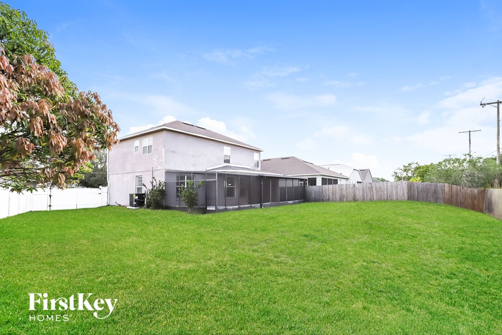 the backyard of a house with a yard and a fence