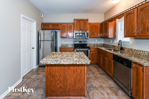 A kitchen with wooden cabinets and granite countertops.