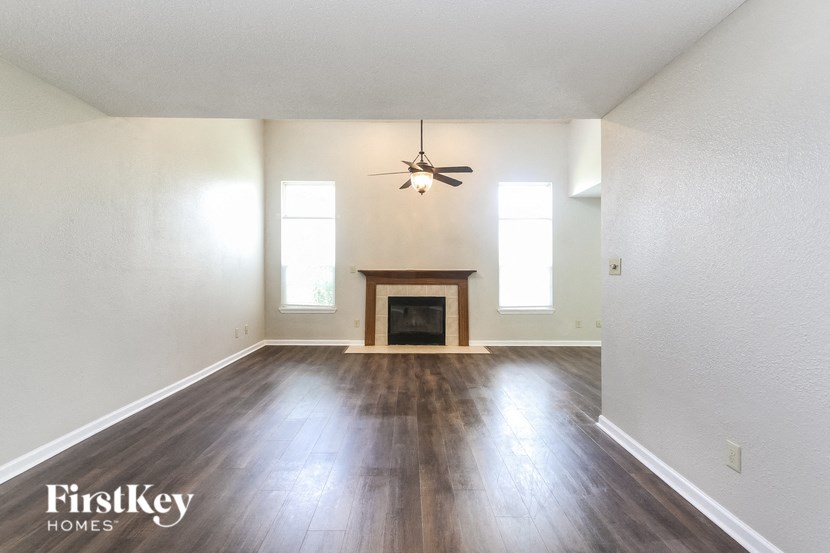 an empty living room with wood floors and a fireplace