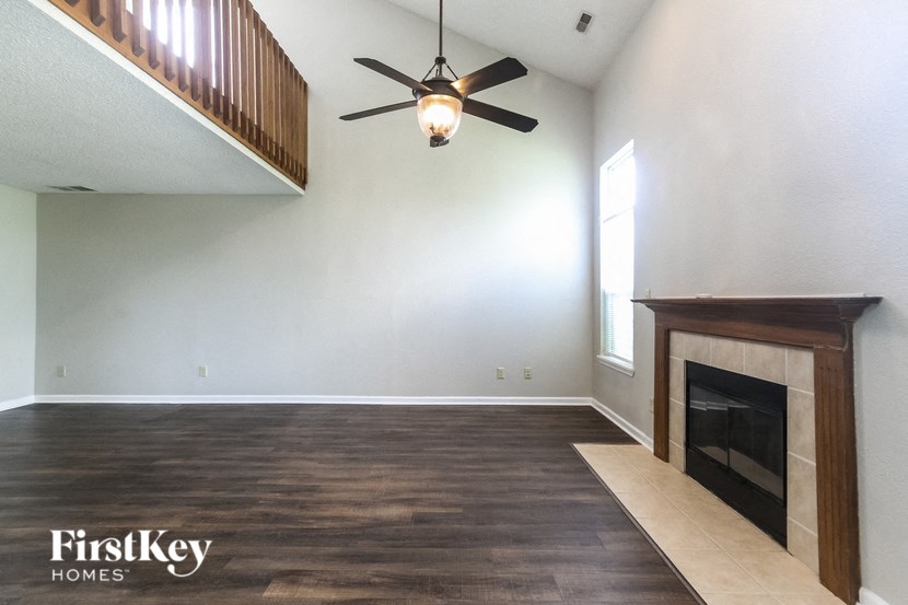 a living room with a fireplace and a ceiling fan