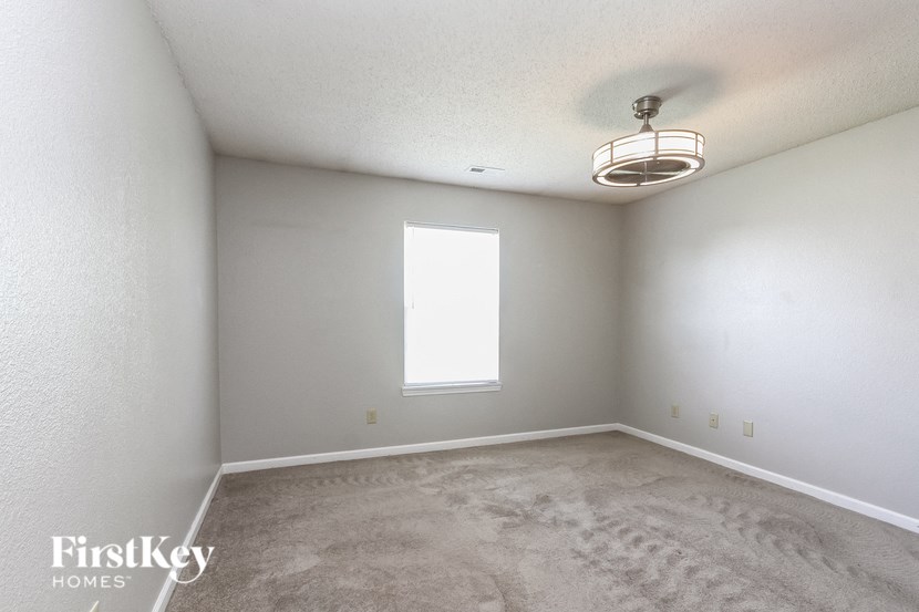a empty living room with carpet and a window