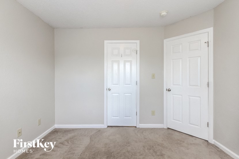 a bedroom with two white doors and a carpeted floor