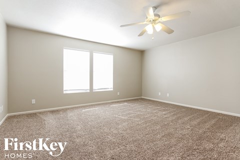 a bedroom with a carpeted floor and a ceiling fan