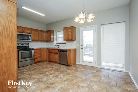 A kitchen with wooden cabinets and a tile floor.