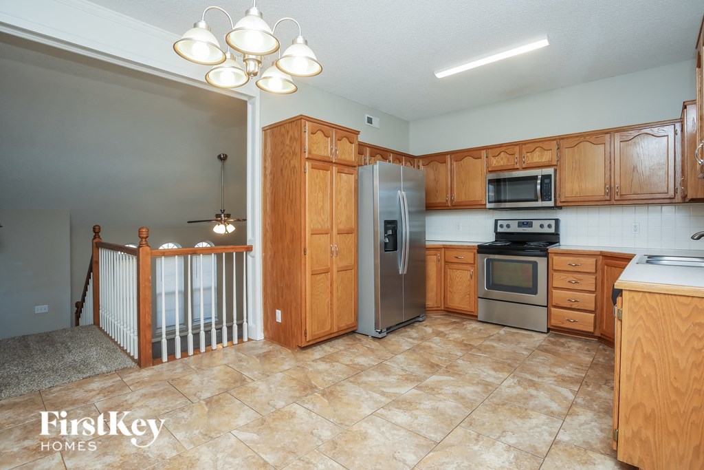 A kitchen with wooden cabinets and a tile floor.