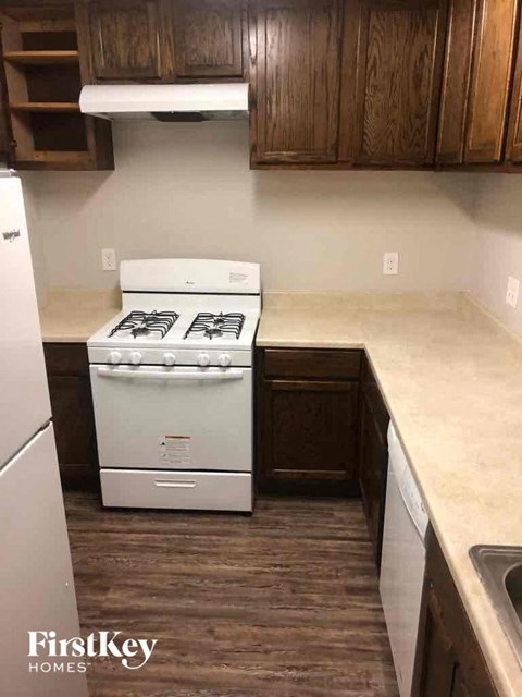 A white stove in a kitchen with wooden cabinets.