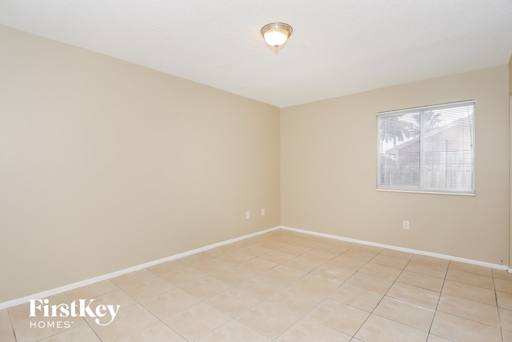 the living room of an empty home with a tiled floor