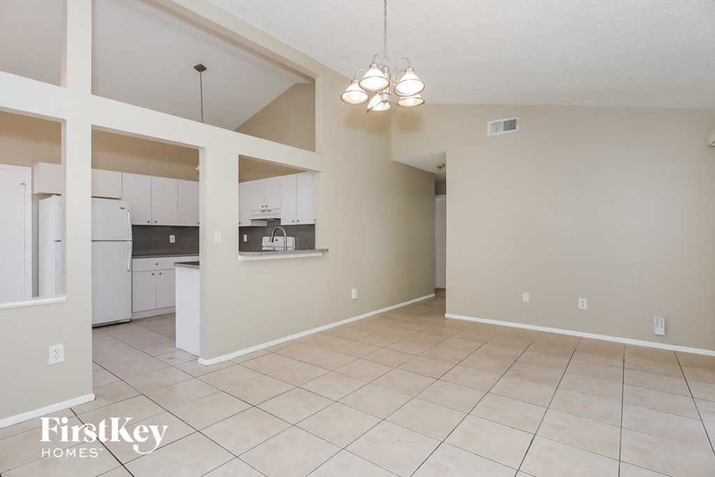 an empty kitchen and living room with a tile floor