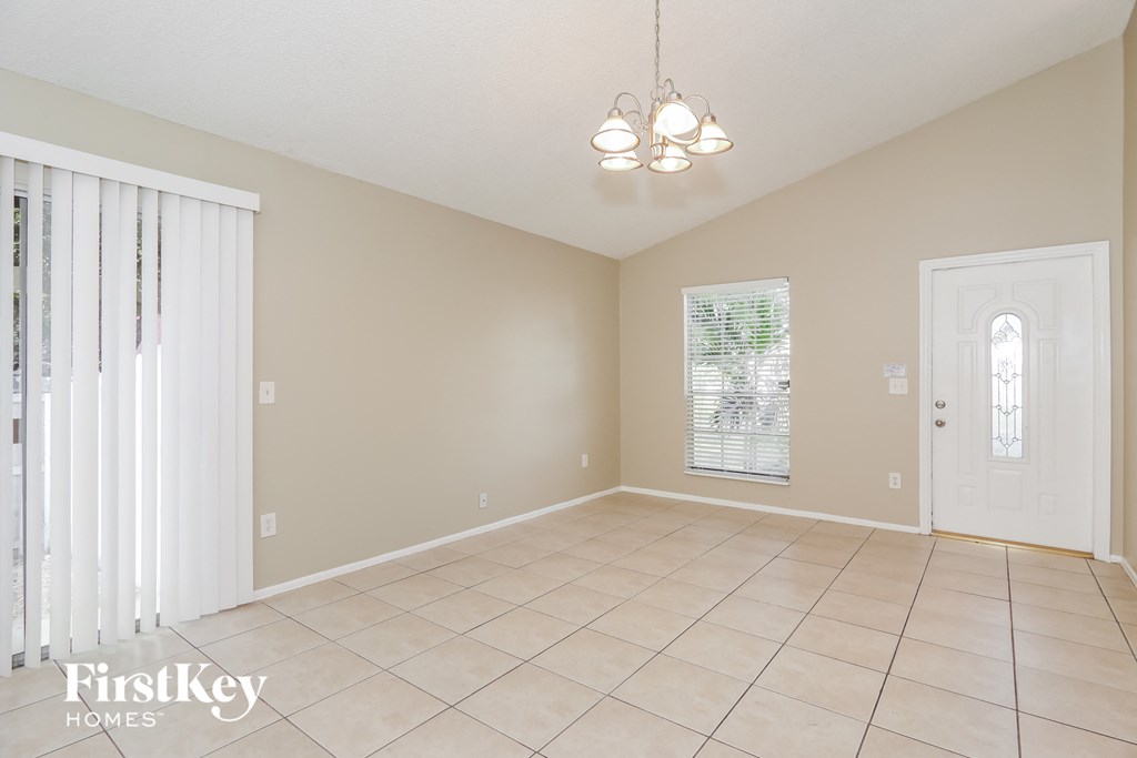 an empty dining room with a door to the kitchen