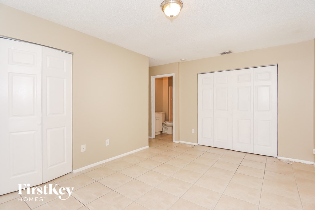 the living room and entrance to the master bedroom with two closets and two doors