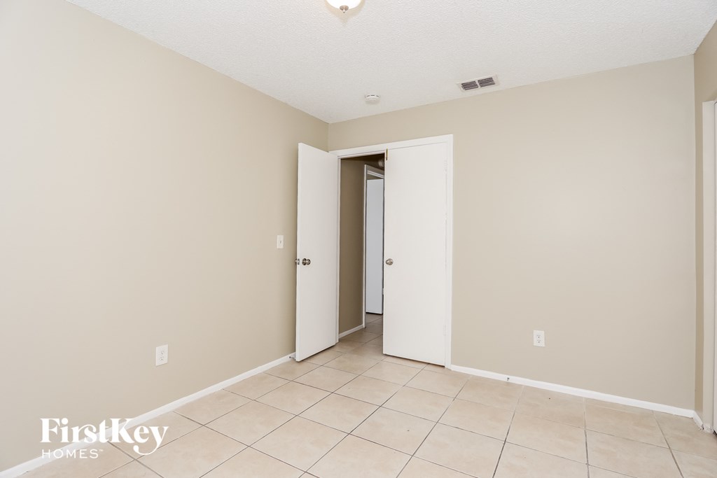 the living room and entryway of an empty house with a tiled floor