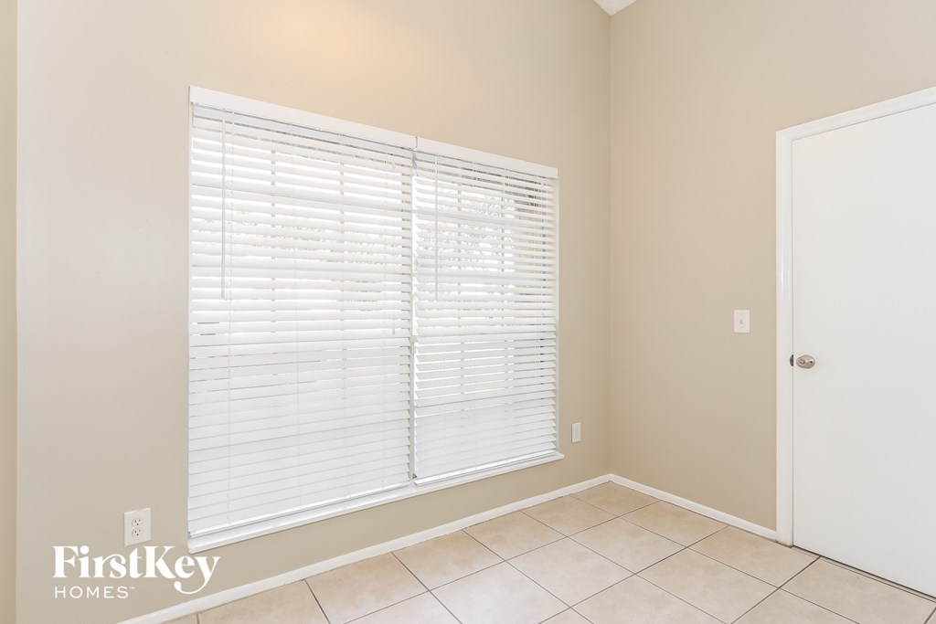 a room with a large window and a tiled floor and a white door