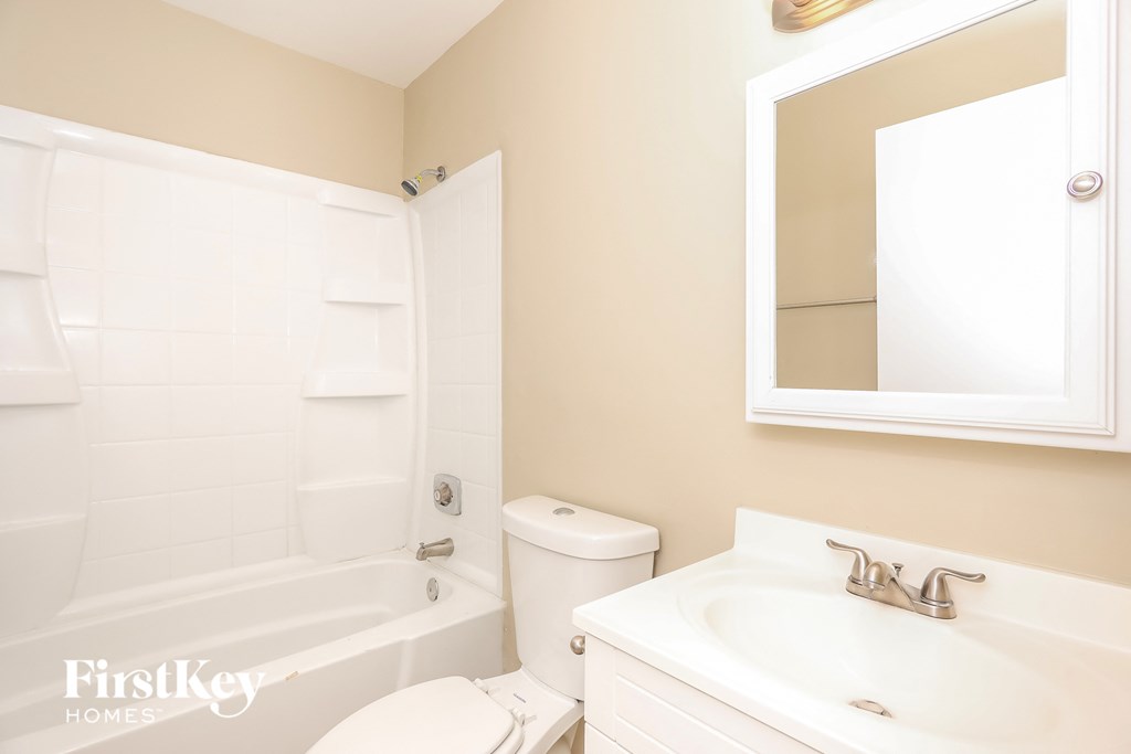 a white bathroom with a sink toilet and tub